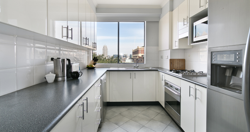 A kitchen with stainless steel appliances and a view of the city.