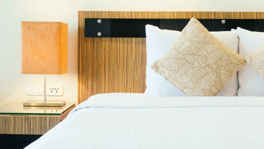 A bed with a headboard and pillow