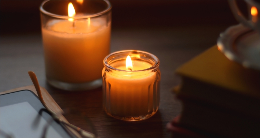 Two candles and a book on a table.