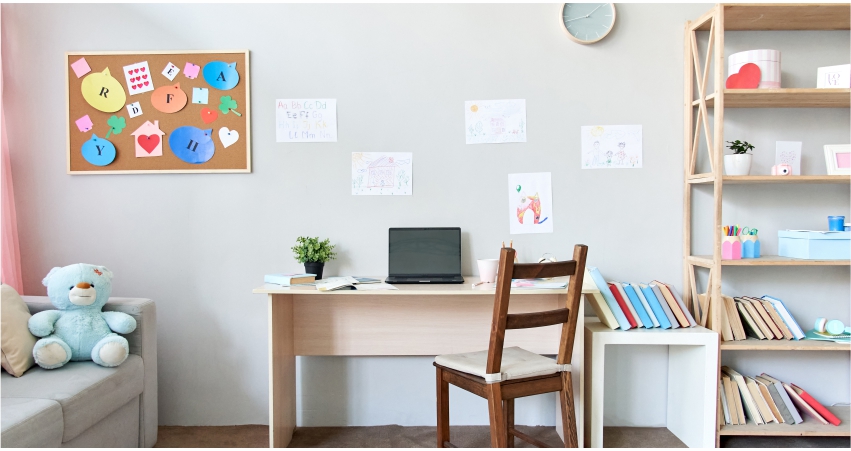 A child's room with a desk, bookshelf, and a teddy bear.