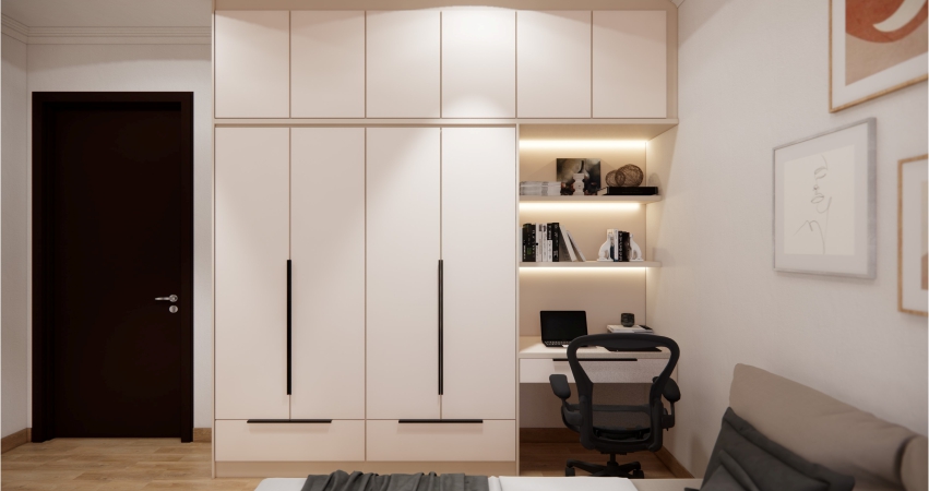 A small bedroom with white cabinets and a study desk.