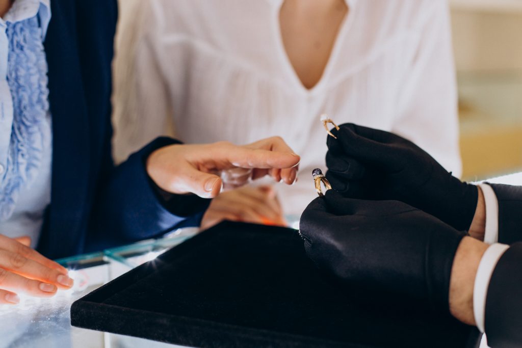 A woman is putting a ring on a woman's finger.
