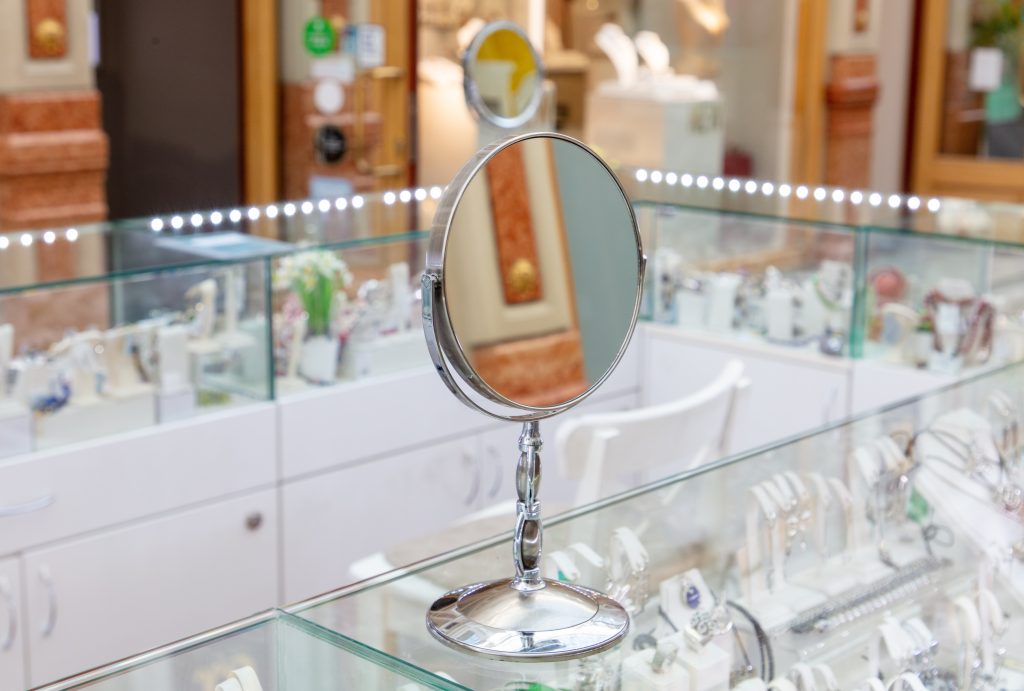 A mirror is on display in a jewelry store.