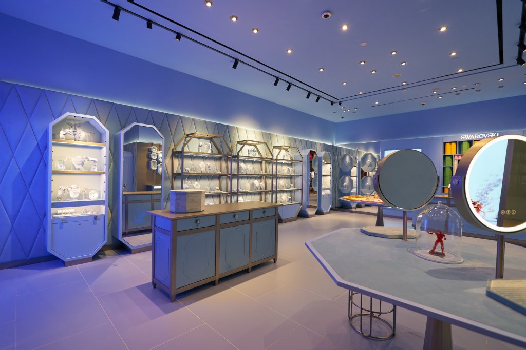 The interior of a jewelry store with blue lights and mirrors.