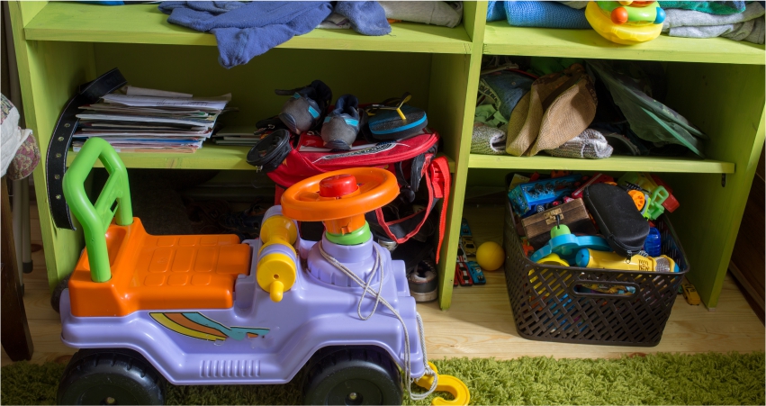 A cluttered children's play area with toys and items strewn about.