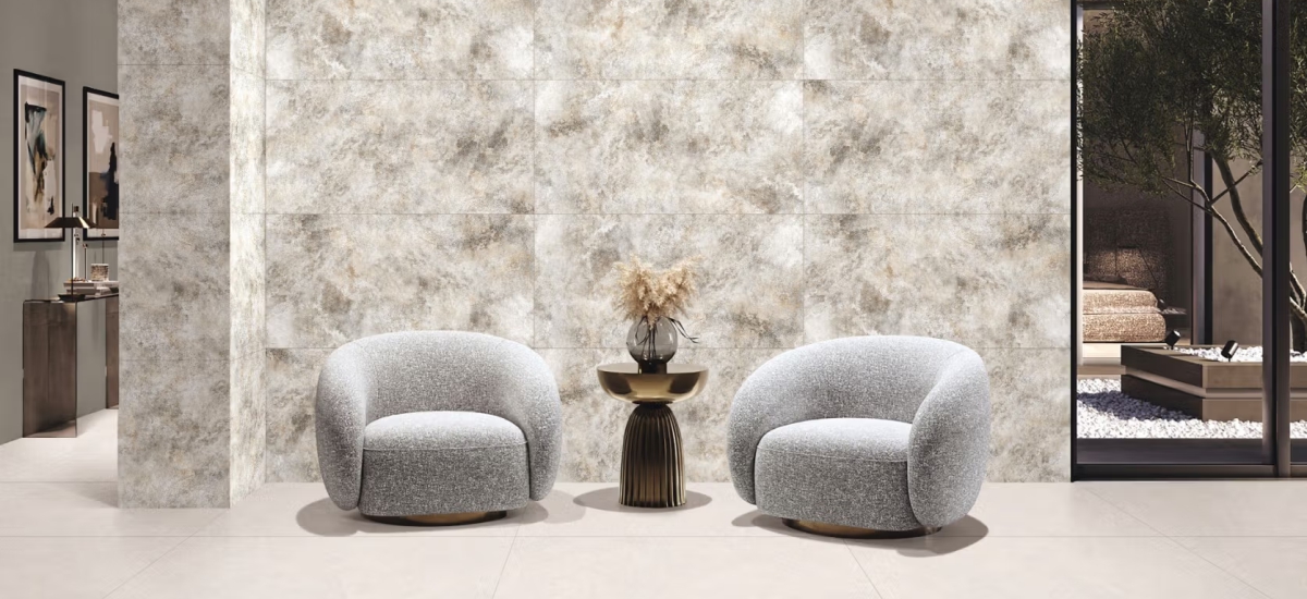 Classy living room interior with grey coloured accent chairs and designer smoky wall tiles that enhance warmth and spaciousness. 