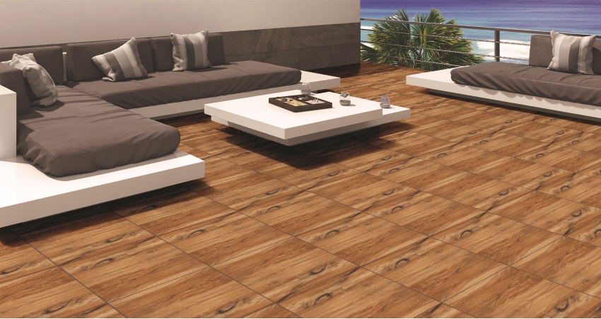 Outdoor patio with wood look floor tiles in a cozy beachside setting, featuring modern white seating and a low coffee table
