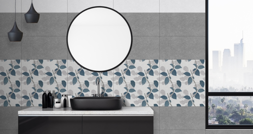 A modern bathroom with flower-patterned tiles, round mirror, and a black sink.
