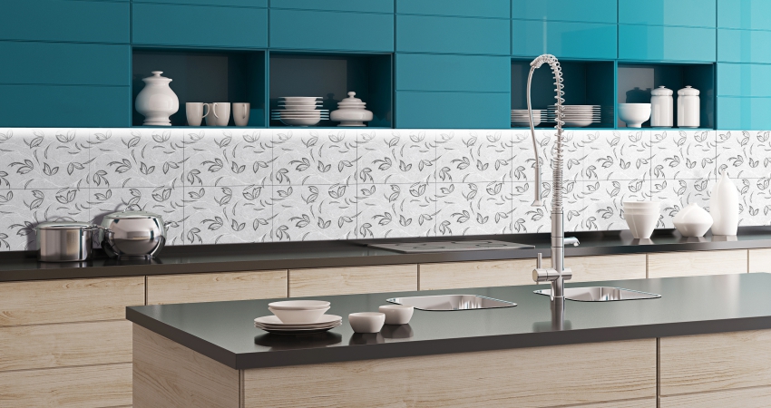 Classic kitchen with teal cabinets, black countertop, and flower-patterned tile backsplash