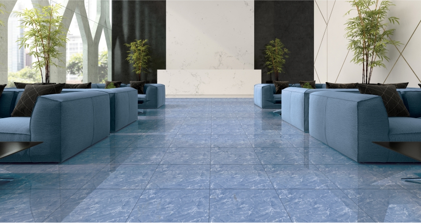 Spacious lounge with blue marble flooring tiles, blue sofas, and potted plants by windows