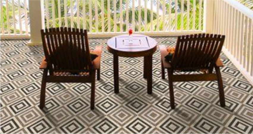 Two wooden chairs and a round table on a patio with a geometric-patterned tile floor